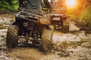 back of an atv going through the mud