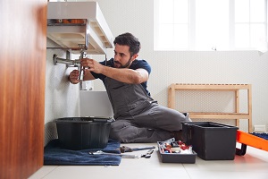 male plumber working on sink